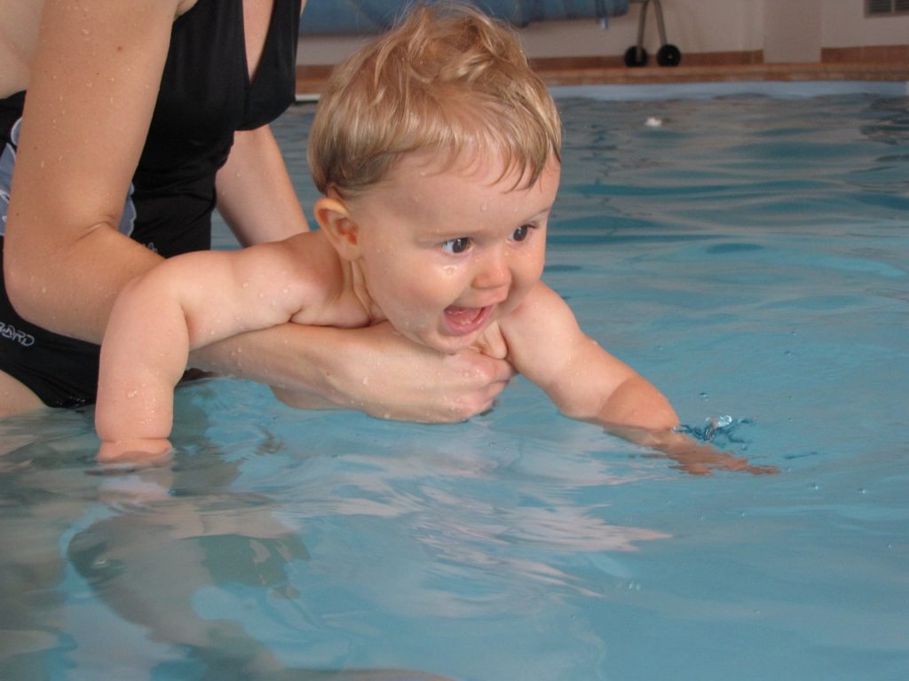 bébé qui nage dans la piscine en plein été. Trouvez tous les accessoires dans le magasin bio pour bébés à casablanca au maroc